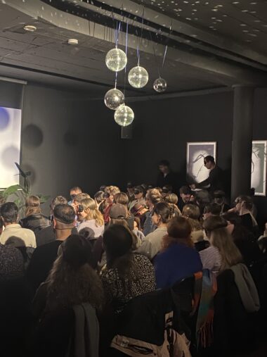 Im Mainzer Off haben die Teilnehmenden des Club Amore Events Augenmasken auf, damit das Blind Date auf der Bühne funktionieren kann. Der Raum ist dunkel, an der Decke hängen einige Discokugeln.